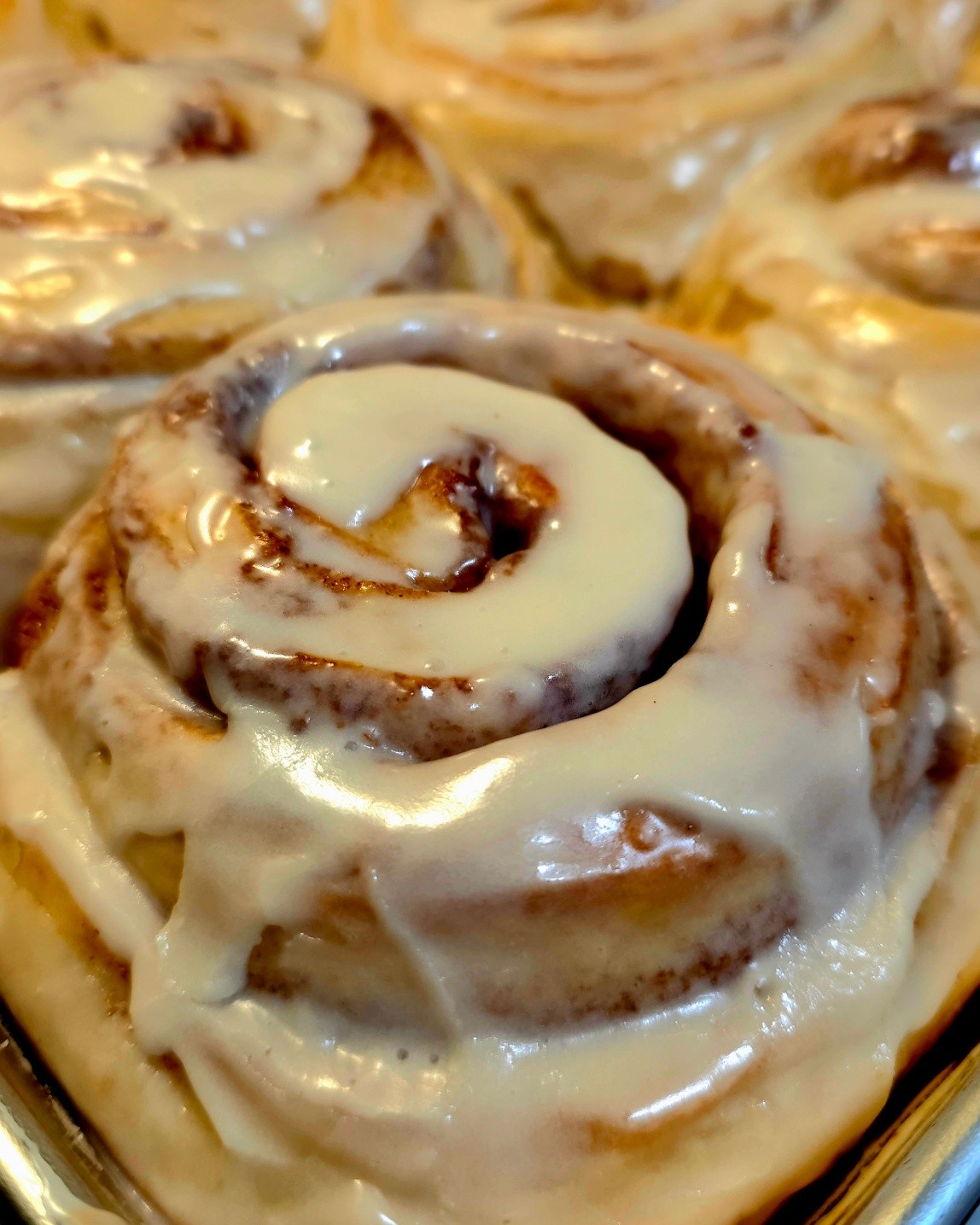 A close-up of a single cream cheese cinnamon roll
