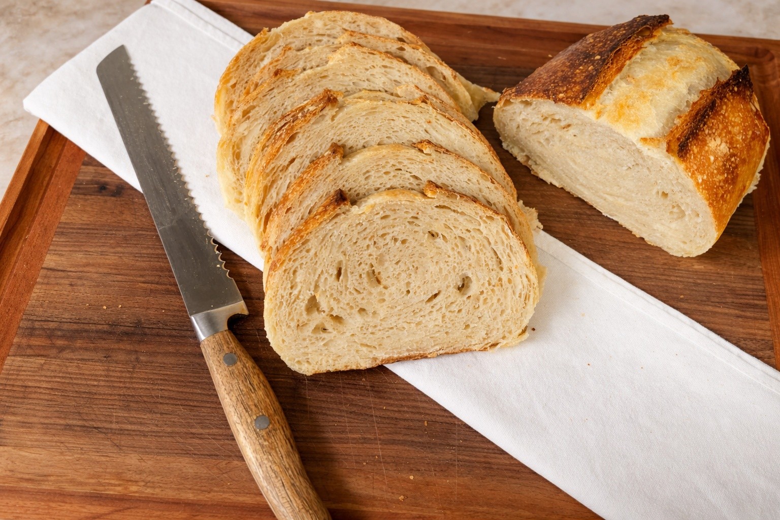 A sliced sourdough loaf showing open, airy crumb